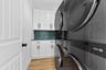 Laundry room featuring double washers and dryers, folding station and storage and cabinets