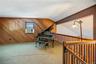 The balcony of the family room looks down into the living room and to the fireplace.