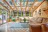 This stunning room is filled with natural light thanks to the dramatic full-glass walls & ceiling.
