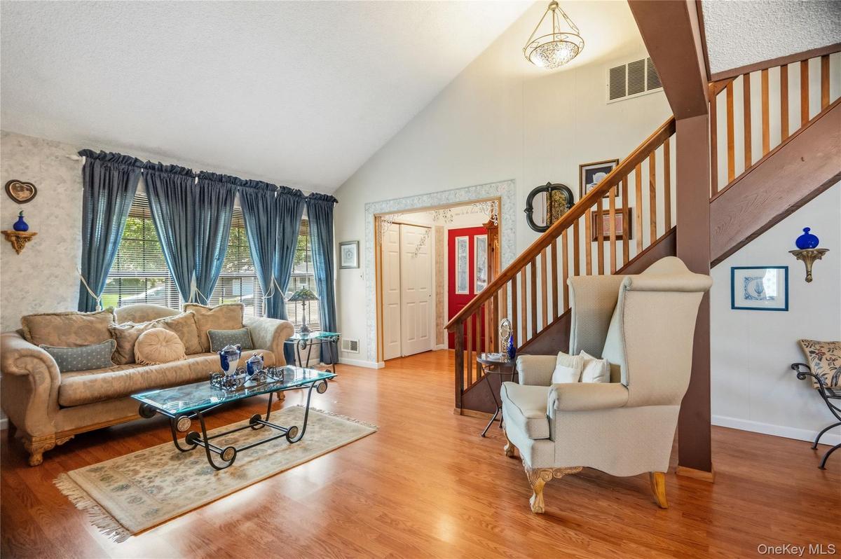 The view from the dining room back towards the living room and the entrance foyer with its large coat closet &  red front door.