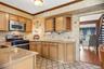 The kitchen features light toned wood cabinets, granite counter tops, a tiled backsplash, built in wine storage and is accented by the darker toned cr