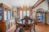 The spacious dining area can accommodate a large table & china cabinet, and features a decorative chandelier and large triple windows.