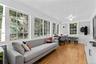 Sun room featuring wood-finish flooring, beadboard ceiling, and multiple grid-pattern windows, and built-ins.
