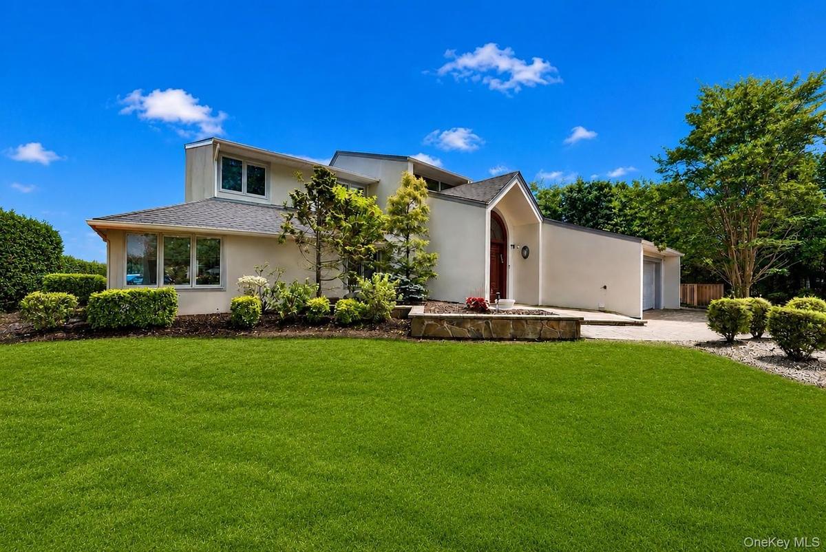 Contemporary exterior design with an arched entry and an attached garage