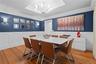 Dining room featuring wood-finish flooring, white wainscoting, and a tray ceiling.