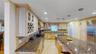 Spacious kitchen featuring light wood cabinetry, granite countertops, stainless steel appliances, a large center island, and recessed lighting
