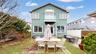 Two-story exterior with a stucco finish and a second-floor balcony featuring glass railing