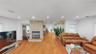 Living area featuring wood-finish flooring, a stone-clad fireplace, recessed lighting, and built-in ceiling speakers