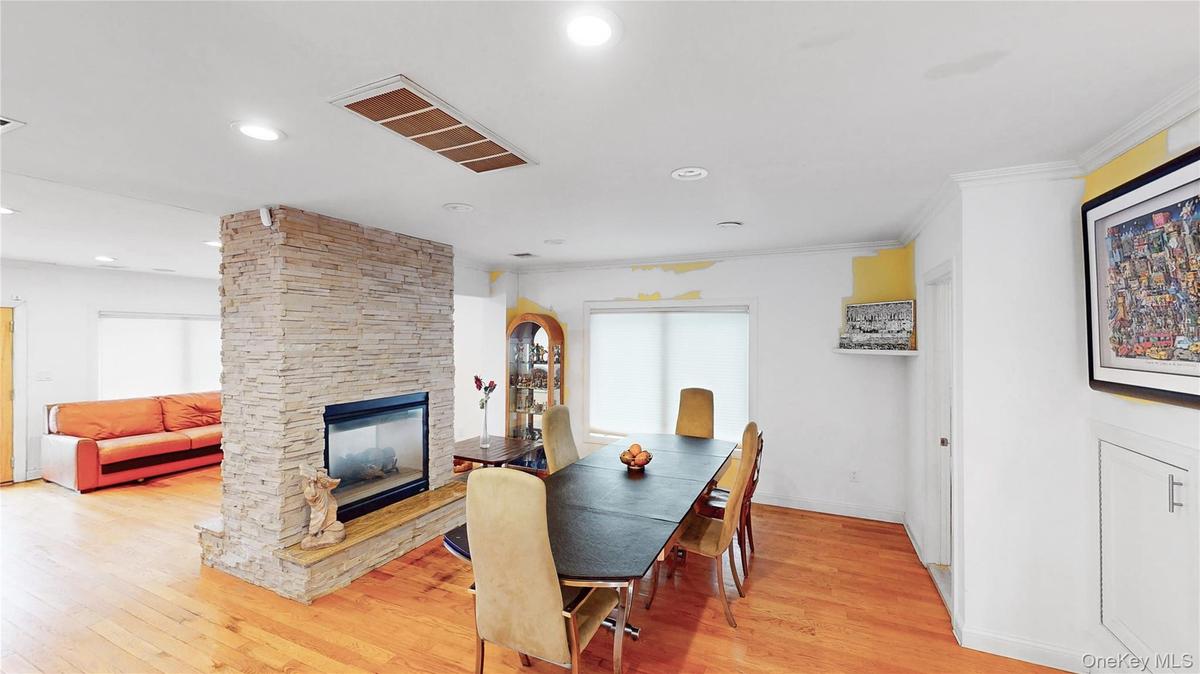 Stone-clad fireplace with a raised hearth separating two distinct areas