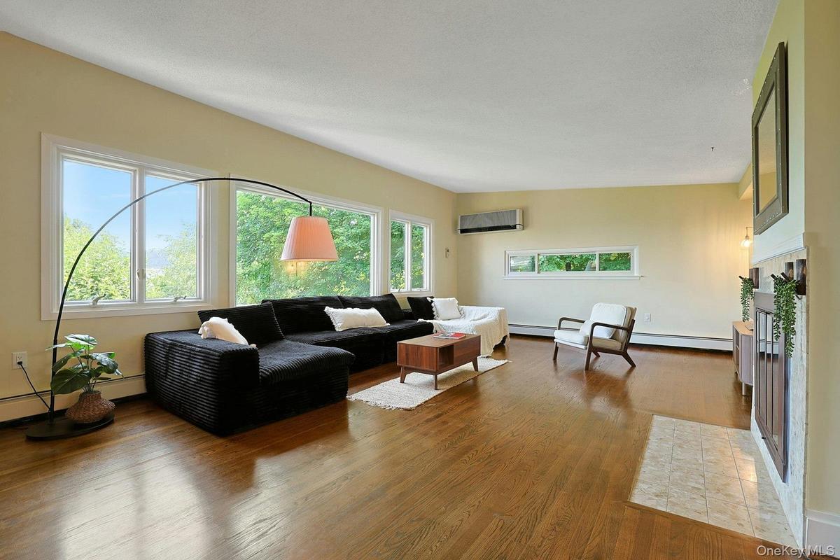 Both deep and wide, the living room has space for so much seating, and countless design opportunities. The wood floors glow under the natural light.