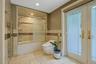 Beautifully tiled, the spa-like bathroom also has a tub with glass enclosure.
