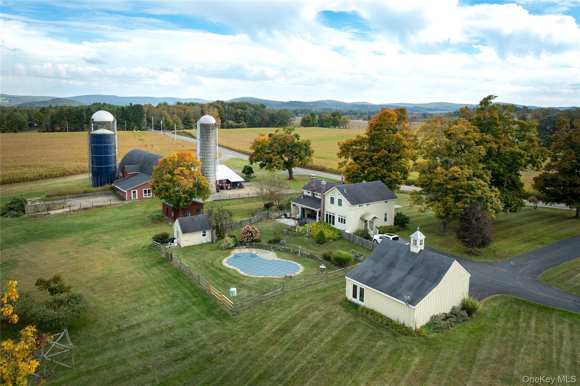 Close up of back of farm with barns, main house, pool area