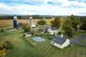 Close up of back of farm with barns, main house, pool area