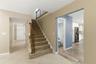 View of entry doors, half bath, kitchen and stairs
