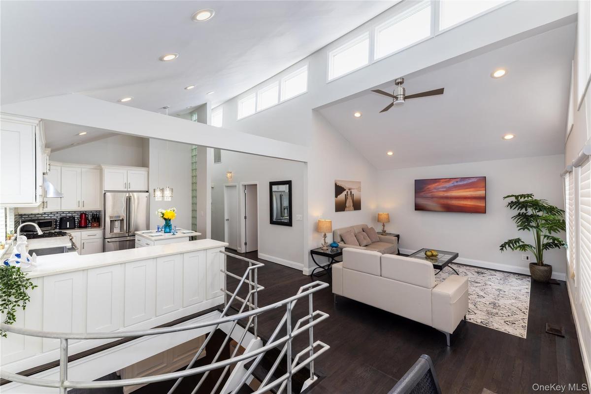 Expansive open-concept living area featuring a vaulted ceiling and dark wood-finish flooring