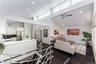 Expansive open-concept living area featuring a vaulted ceiling and dark wood-finish flooring