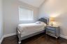 Bedroom featuring dark wood-finish flooring.