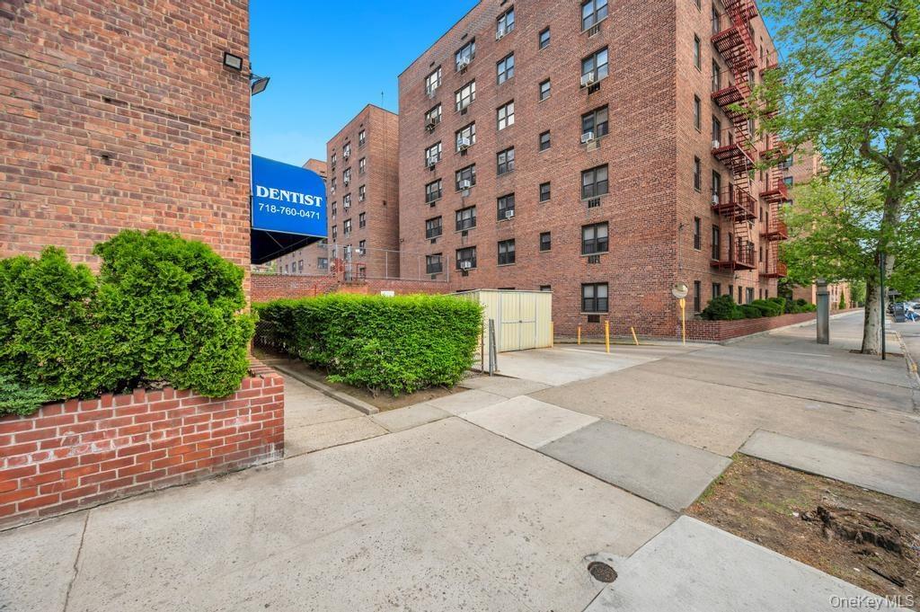 Brick apartment building exterior featuring multiple windows and exterior fire escapes