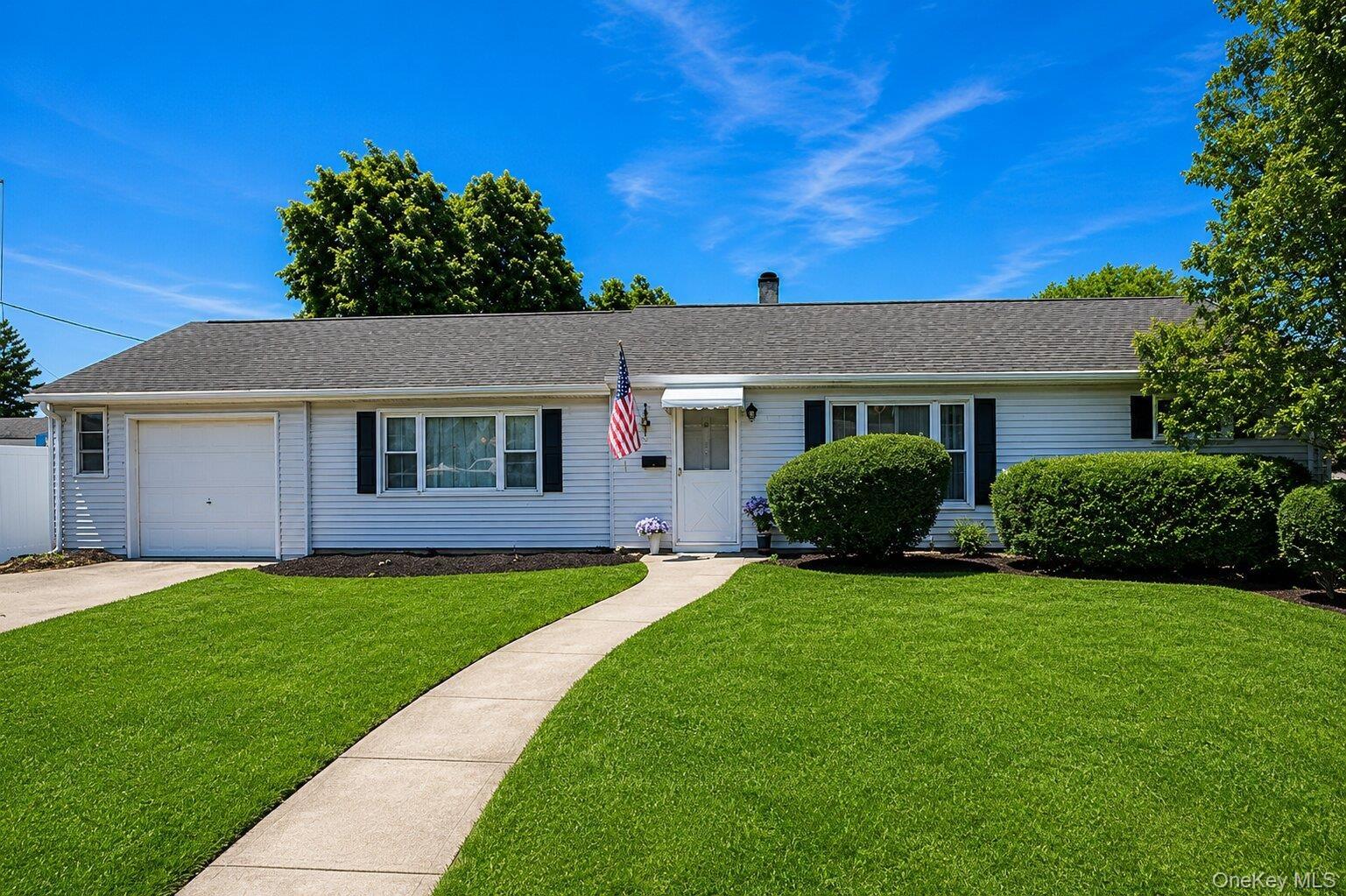 Ranch-style residence featuring white siding, a dark shingle roof, and a single-car garage