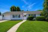 Ranch-style residence featuring white siding, a dark shingle roof, and a single-car garage