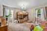 Carpeted room featuring dual windows with white trim, a crystal chandelier, and neutral painted walls