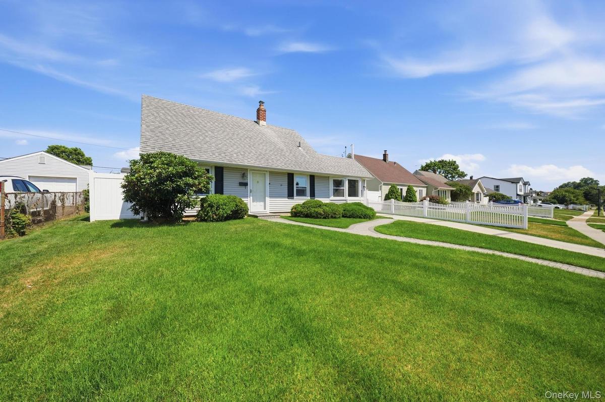 Single-story home featuring a gray shingle roof, light-colored siding, and dark shutters