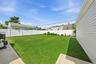 Expansive green lawn with a white privacy fence