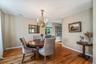 Dining area featuring hardwood flooring, a brass chandelier, a built-in wall niche, and an arched entryway