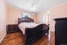 Bedroom featuring wood-finish flooring, a ceiling fan, and a mini-split air conditioning unit