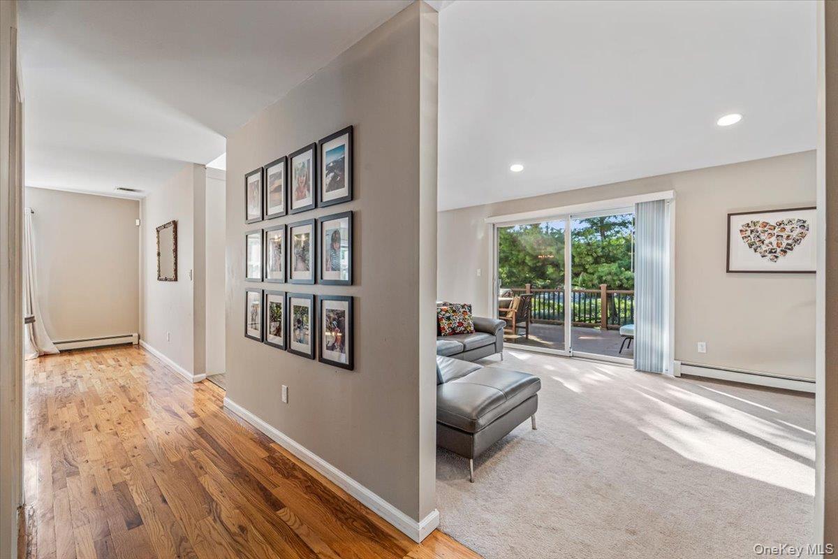 Living area featuring light-toned carpeting and recessed lighting