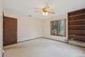Carpeted empty room with ceiling fan and baseboard heating