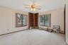 Empty room featuring carpet floors, a baseboard heating unit, and a ceiling fan