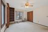 Unfurnished bedroom with carpet flooring, ceiling fan, and a baseboard heating unit