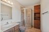 Full bath featuring light tile patterned flooring, vanity, and a stall shower