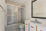 Full bathroom featuring shower / bath combination with glass door, vanity, and light tile patterned floors
