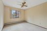 Carpeted spare room featuring a baseboard radiator and ceiling fan