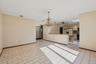 Spare room featuring a ceiling fan, a chandelier, a skylight, and light tile patterned floors