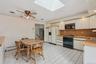 Kitchen featuring black appliances, light countertops, a skylight, and white cabinets