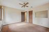 Unfurnished bedroom featuring carpet floors, a baseboard radiator, a closet, and a ceiling fan