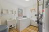 Washroom featuring water heater, light tile patterned floors, separate washer and dryer, and a heating unit