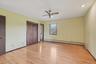 Unfurnished bedroom featuring light wood-style flooring, two closets, a ceiling fan, and baseboard heating