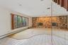 Unfurnished living room featuring carpet floors, a fireplace, and a baseboard heating unit
