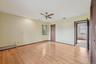 Unfurnished room with light wood finished floors, a baseboard heating unit, and a ceiling fan