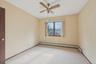 Spare room with carpet, ceiling fan, and a baseboard heating unit