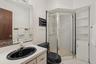 Full bath featuring a stall shower, vanity, and light tile patterned floors
