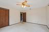 Unfurnished bedroom featuring carpet flooring, ceiling fan, and a closet