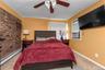 Bedroom with baseboard heating, carpet, ceiling fan, and cooling unit