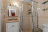 Full bathroom featuring tile walls, vanity, and a stall shower