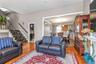 Living room with wood finished floors, stairway, a chandelier, and ornamental molding