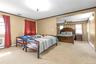 Bedroom with crown molding, light colored carpet, and a baseboard radiator